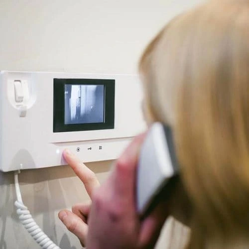 Person using a wall-mounted video intercom